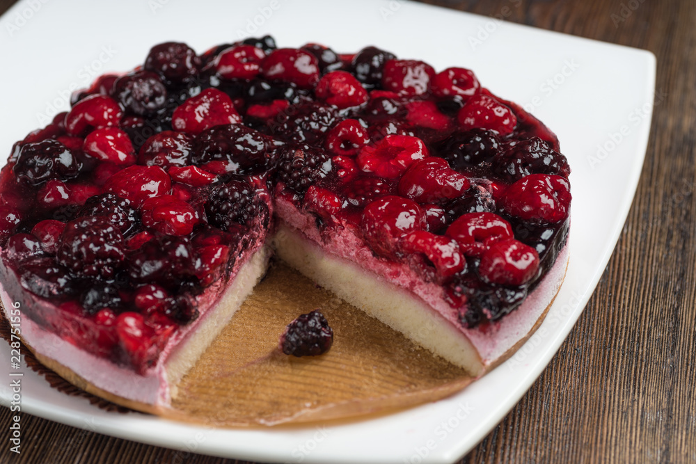 Mousse cake with berries on wooden background Mousse cake with berries on wooden background