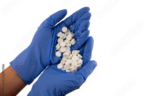 The drug on a white background. Hands in blue gloves..