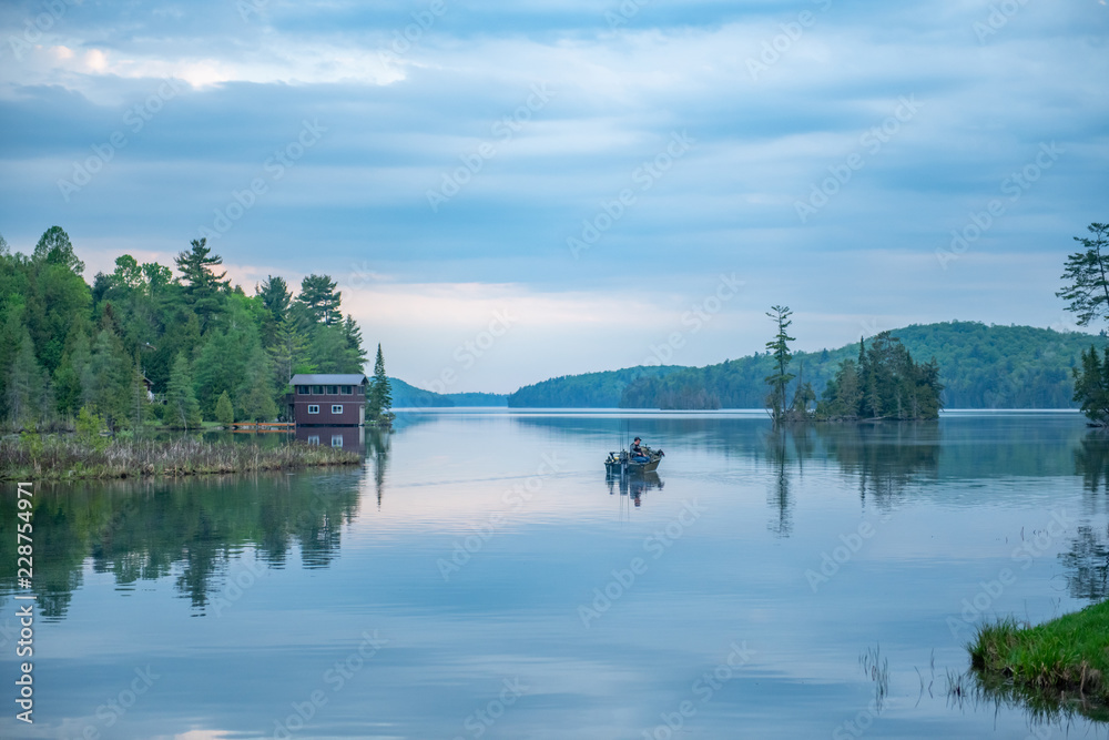 Calm Palmerston Lake with a fisherman in a boat