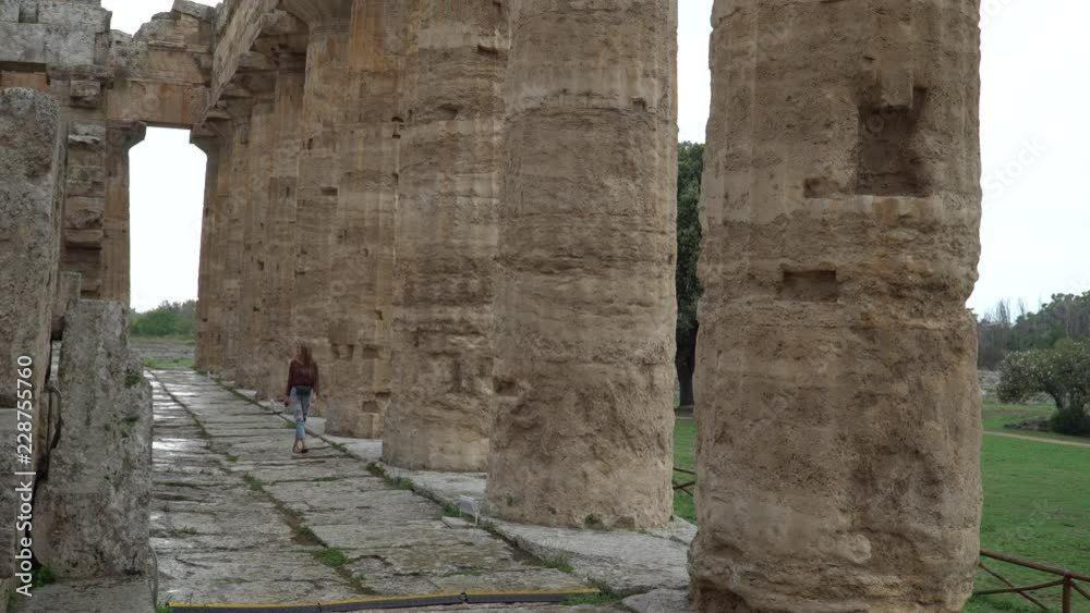 Pretty girl look at Second Temple of Hera  - a Greek temple in Paestum, Italy. 4K.