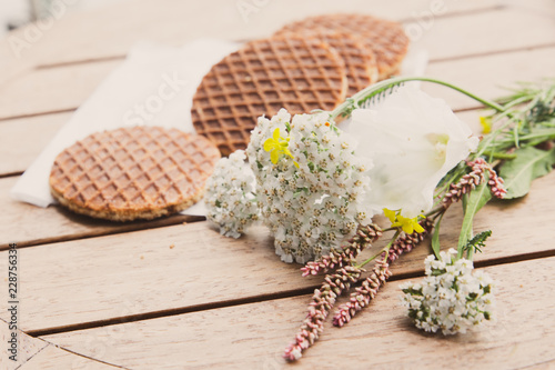 Traditional Dutch Stroopwafels syrup filled waffle cookies in setting with flowers