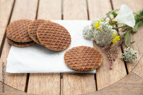 Traditional Dutch Stroopwafels syrup filled waffle cookies in setting with flowers