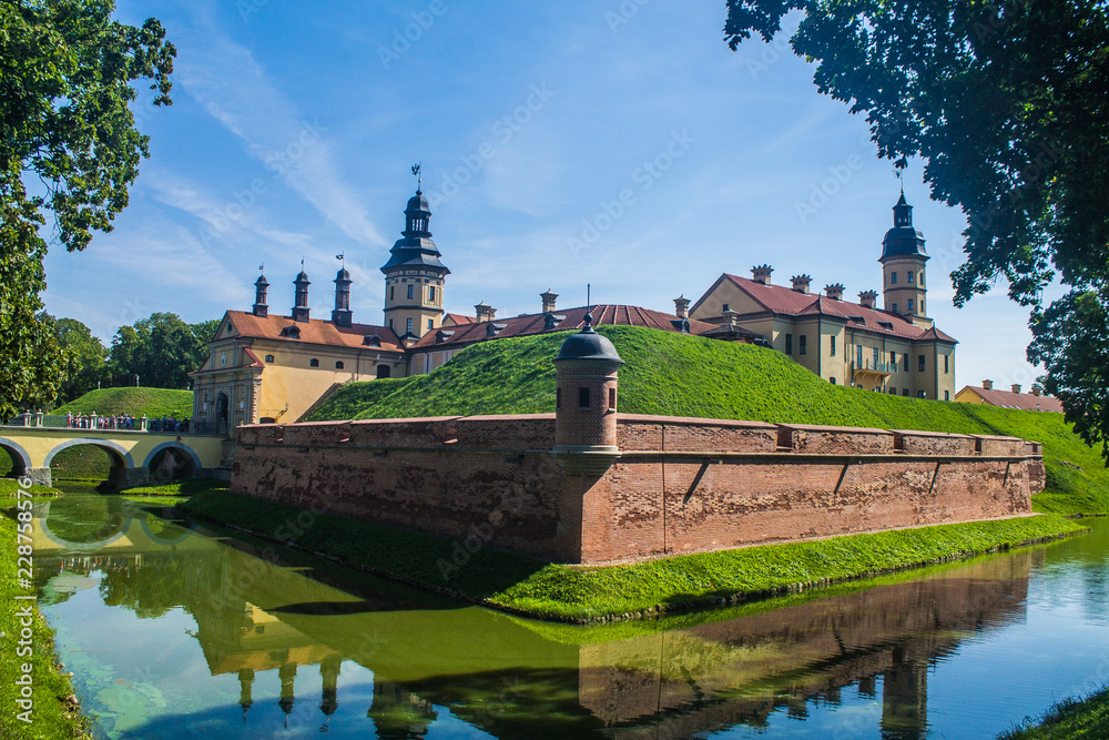 View of Nezvish Palace on a beautiful sunny day of a summer in the Minsk region, in Belarus - Different styles, the fortification is an UNESCO heritage site, also known as Niasvižski zamak.