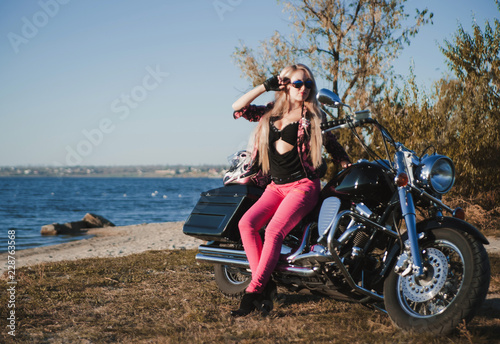 Beautiful woman posing on motorcycle outdoor. 