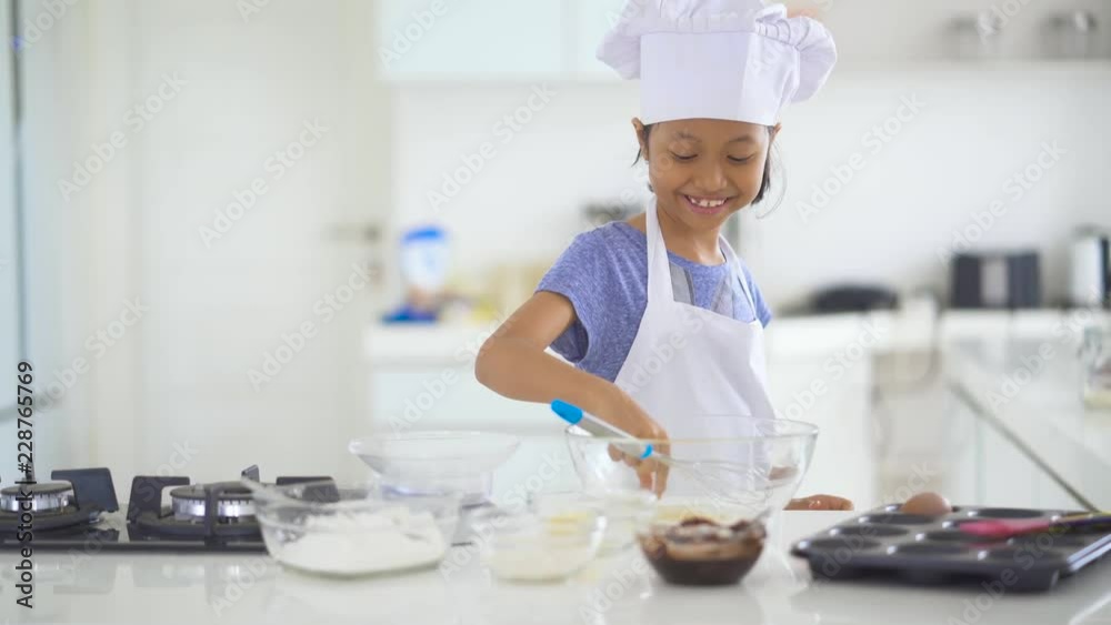 Cute little girl preparing the dough, bake cookies in the kitchen. Shot in 4k resolution Cute little girl preparing the dough, bake cookies in the kitchen. Shot in 4k resolution