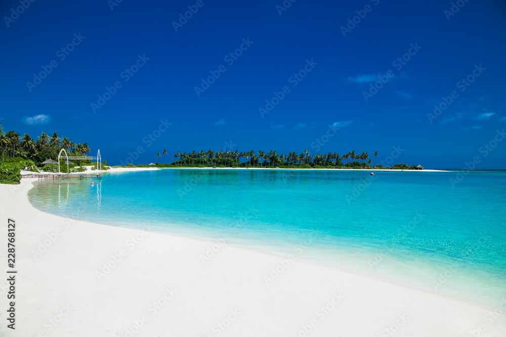 Beautiful beach with white sand at tropical Olhuveli island, Maldives.