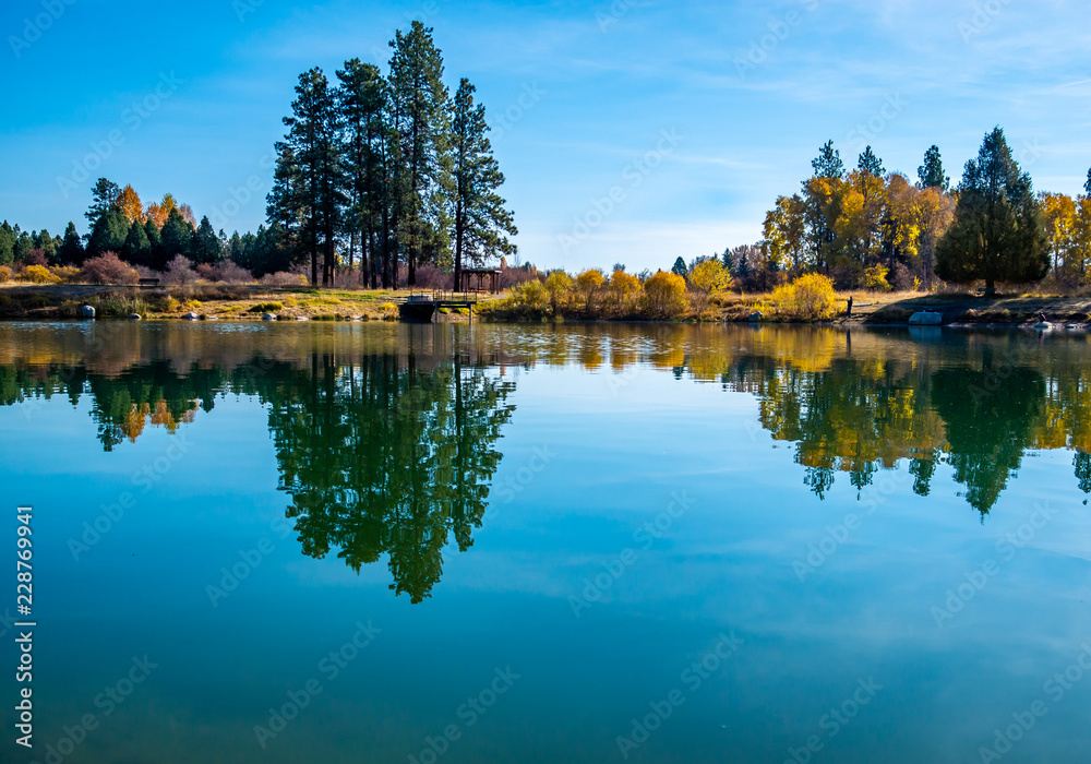 A local trout pond turns into a reflection pool on this calm autumn day in October. A local trout pond turns into a reflection pool on this calm autumn day in October.