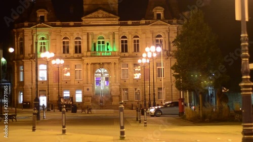 Brightly lit colourful stone building in town square at night photo