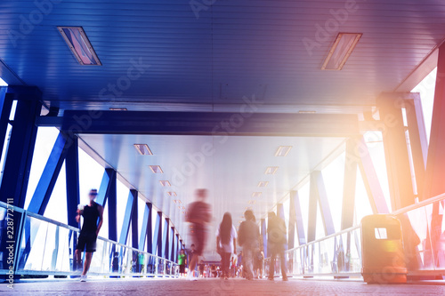 people on foot bridge against sun ray while after work  photo