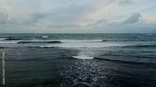 Aerial reveal of sea from snowy black rocks of Sandgerdi Iceland in January photo