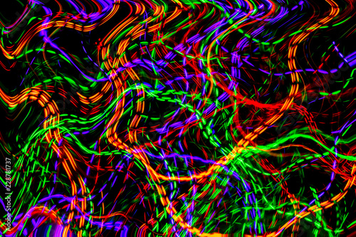 The chaotic lines of color lights on dark background. Colorful lights is move in the black space.