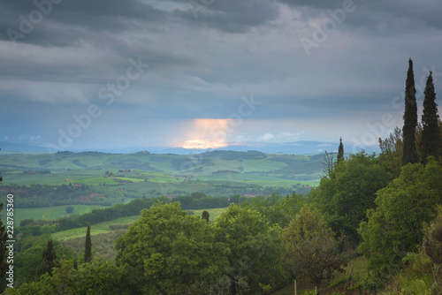 Tuscany cloudy landscape. Typical for the region tuscan farm house, hills, vineyard. Italy