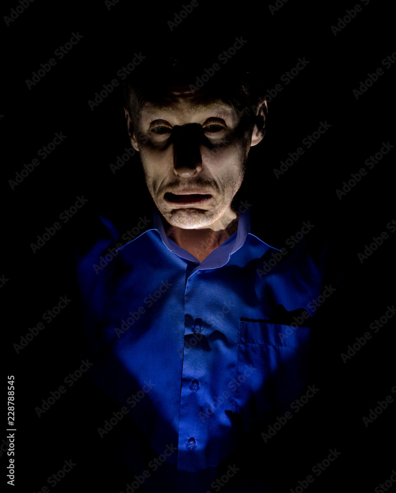 Stylish dark portrait of adult caucasian man who seems like maniac or psycho. Isolated on black background. Low-key lighting. Stylish dark portrait of adult caucasian man who seems like maniac or psycho. Isolated on black background. Low-key lighting.