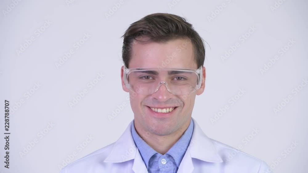Young happy handsome man doctor wearing protective glasses Young happy handsome man doctor wearing protective glasses