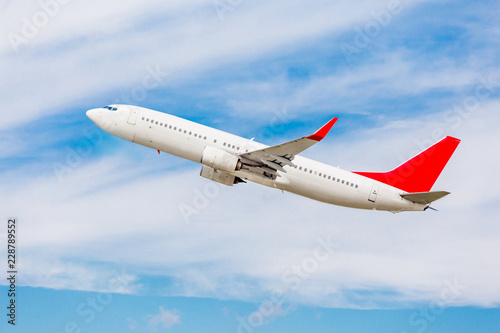 Modern passenger jet aircraft flies in a blue sky. Happy journey and holidays concept.