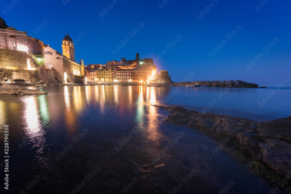 Panorama of night fishing village Vernazza with Santa Margherita di Antiochia Church and lookout tower of Doria Castle, Five lands, Cinque Terre National Park, Liguria, Italy.
