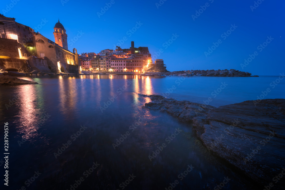 Panorama of night fishing village Vernazza with Santa Margherita di Antiochia Church and lookout tower of Doria Castle, Five lands, Cinque Terre National Park, Liguria, Italy.
