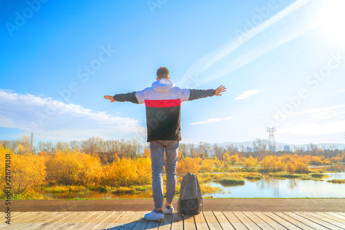 young man alone stands on the embankment of the river back