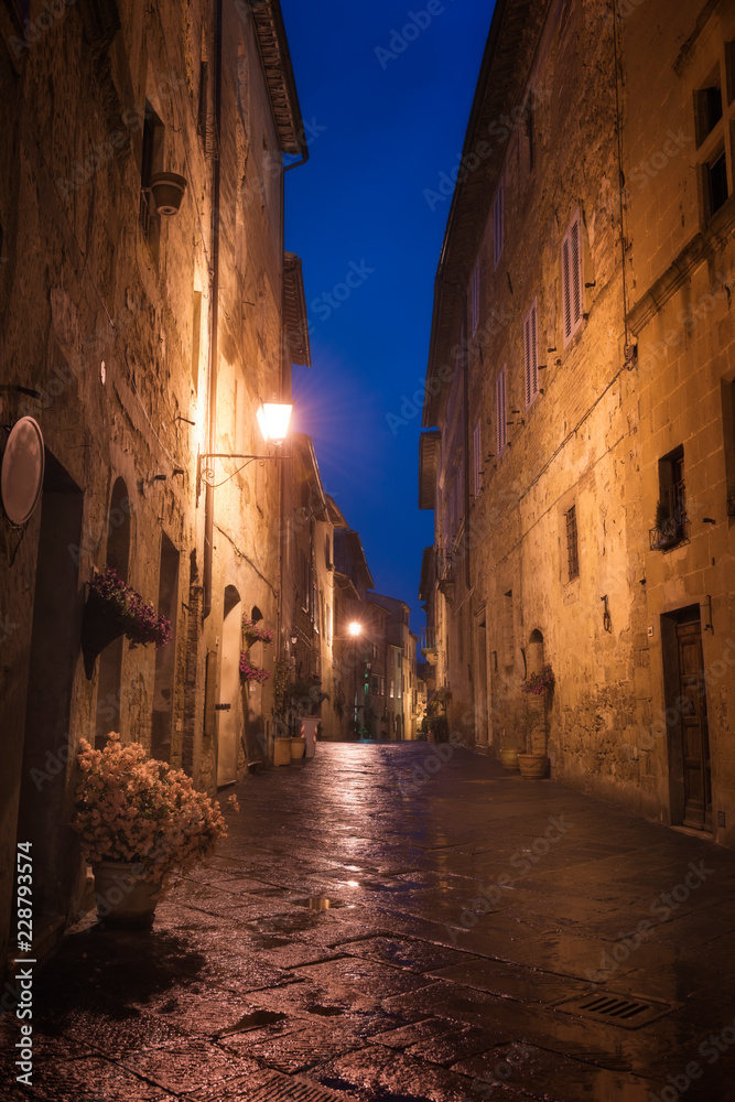 Old European city Pienza street at rainy night, Tuscany, Italy