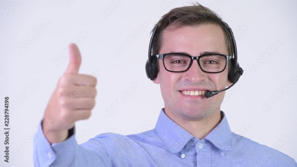 Young happy handsome businessman as call center representative giving thumbs up Young happy handsome businessman as call center representative giving thumbs up