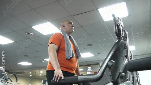 Fat man starting to walk on the treadmill. The view from the bottom up