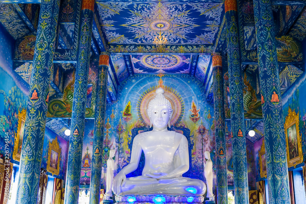 Fototapeta premium White buddha statue in Wat Rong Sua Ten temple with blue sky background, Chiang Rai Province, Thailand, It's a popular destination and Landmark of Chiang Rai