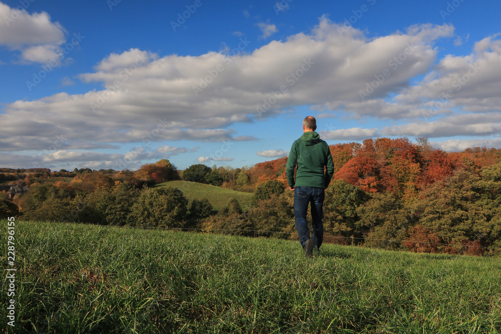 hiking in beautiful fall landscape with green fields and soft hills hiking in beautiful fall landscape with green fields and soft hills