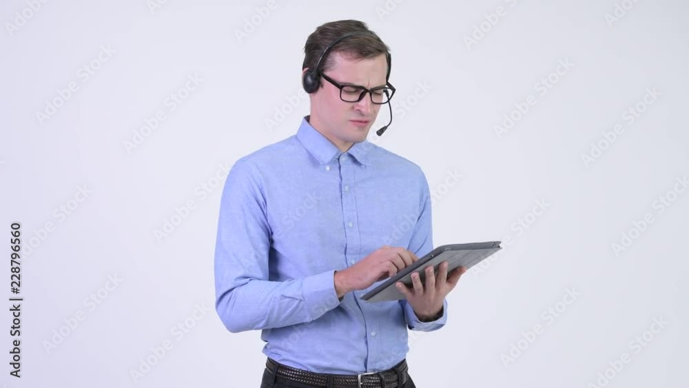 Young annoyed businessman as call center representative using digital tablet