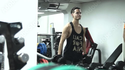 young sportsman is picking big dumbbells then camera moves to a fun fat man with the smallest dumbbells
