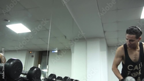 Fatty man is sitting and looking at a beautiful athlete with dumbbels smiling at him, fun video. camera moving