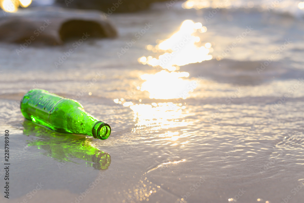 Empty green beer bottle on the beach. Concept of no garbage on beach and environment,copy space. Empty green beer bottle on the beach. Concept of no garbage on beach and environment,copy space.
