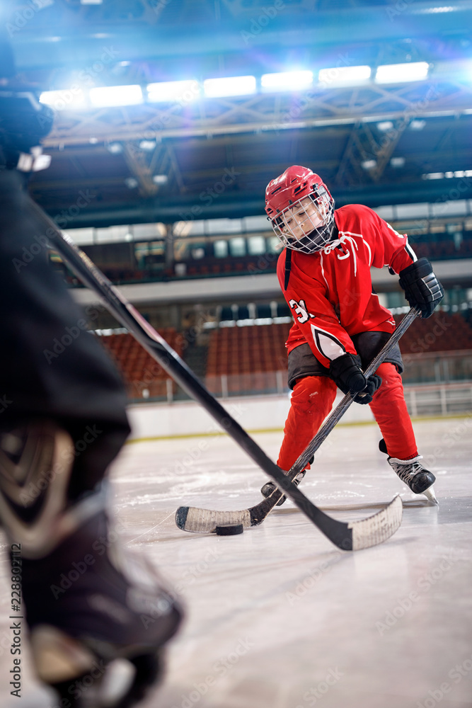 Fototapeta premium boy play ice hockey in action kicking on goal.