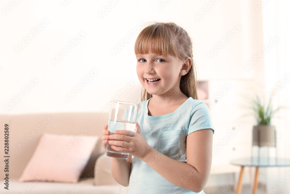Cute little girl holding glass of fresh water at home Cute little girl holding glass of fresh water at home
