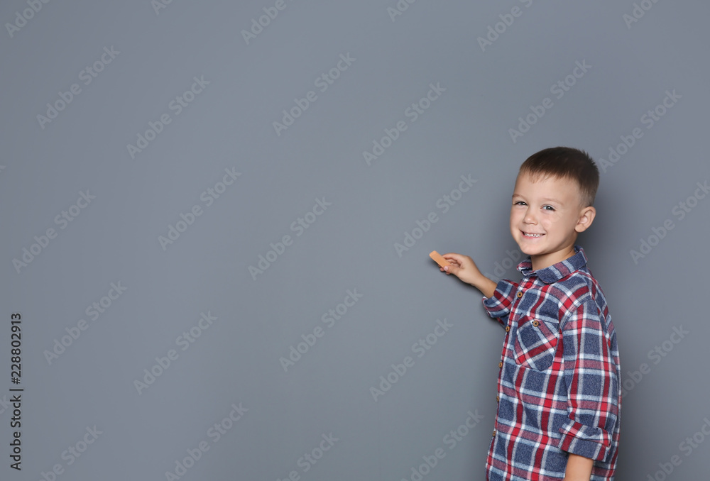 Little boy drawing with colorful chalk on gray background. Space for design Little boy drawing with colorful chalk on gray background. Space for design