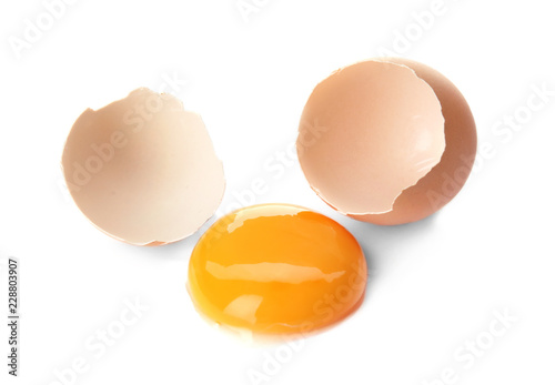 Egg yolk with cracked shell on white background