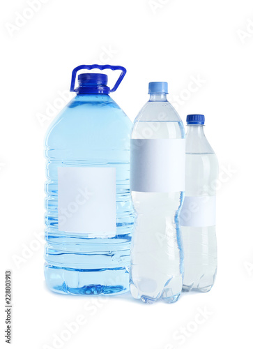 Different bottles of pure water with blank tags on white background