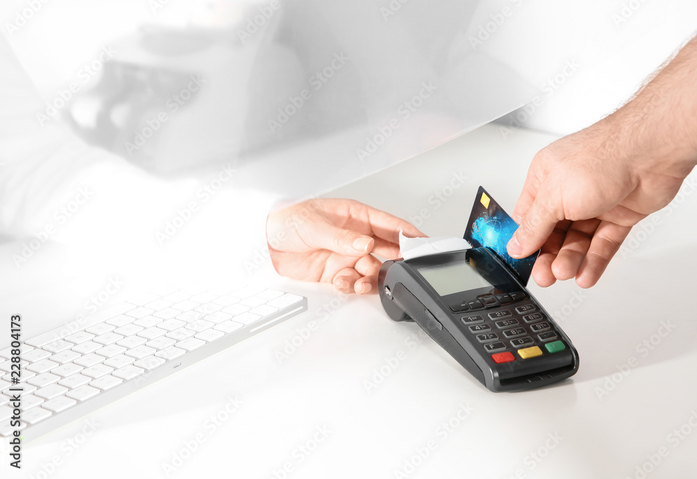 Man using bank terminal for credit card payment at cash department window, closeup Man using bank terminal for credit card payment at cash department window, closeup