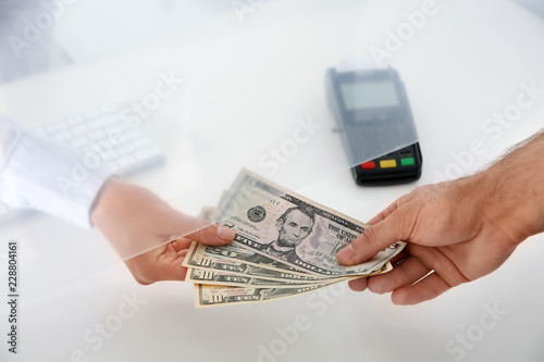 Man giving money to teller at cash department window, closeup