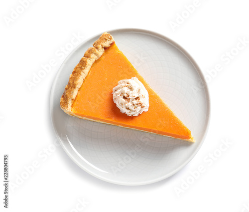 Plate with piece of fresh delicious homemade pumpkin pie on white background, top view