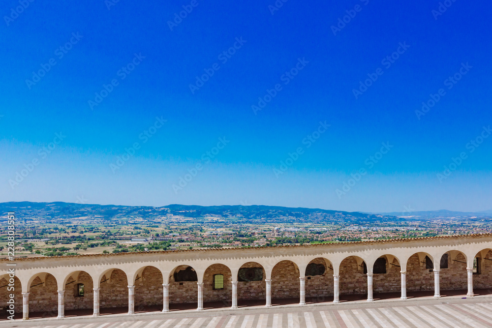 Corridor of lower square of St Francis in Assisi, Italy, with landscape in the distance