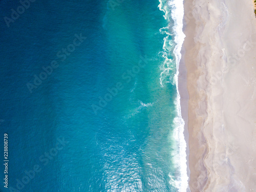 Aerial view of the ocean waves washing on the coast of the Pacific ocean