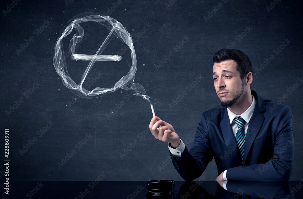 Businessman smoking cigarette and the smoke forms a no smoking sign. Businessman smoking cigarette and the smoke forms a no smoking sign.