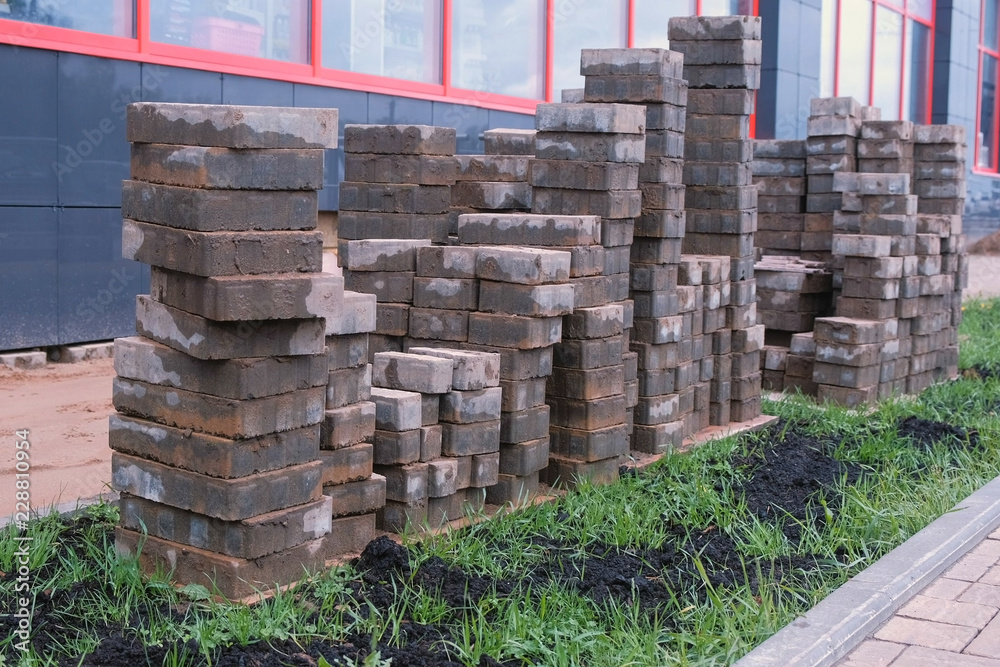 Laying paving slabs in front of the building. Sand and paving slabs in rows. Close-up view. Laying paving slabs in front of the building. Sand and paving slabs in rows. Close-up view.
