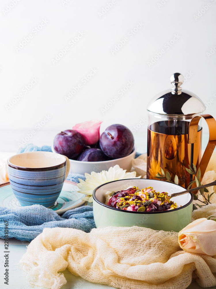 Breakfast with bowl of fresh quark, berries, seeds. Table setting with coffee and flowers Breakfast with bowl of fresh quark, berries, seeds. Table setting with coffee and flowers