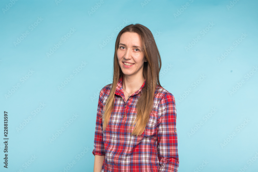 Fototapeta premium Portrait of young attractive caucasian woman in blue background