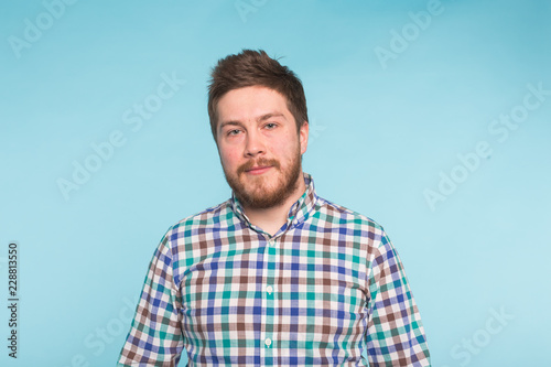 Close-up portrait of bearded handsome man on blue background
