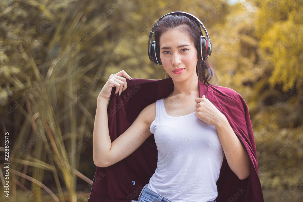Young beautiful woman running in autumn park and listening to music with headphones. Young beautiful woman running in autumn park and listening to music with headphones.