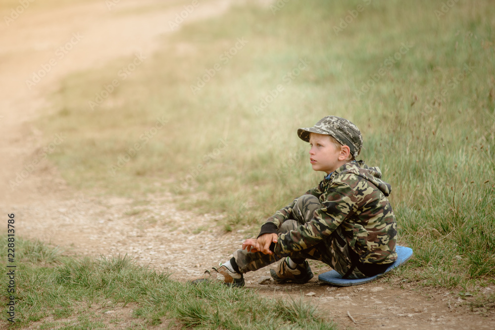 Boy sitting on grass and resting after hiking in Carpathian