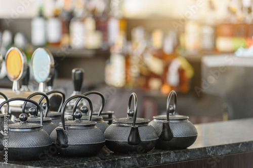 Herbal tea in teapots on bar counter in spa salon