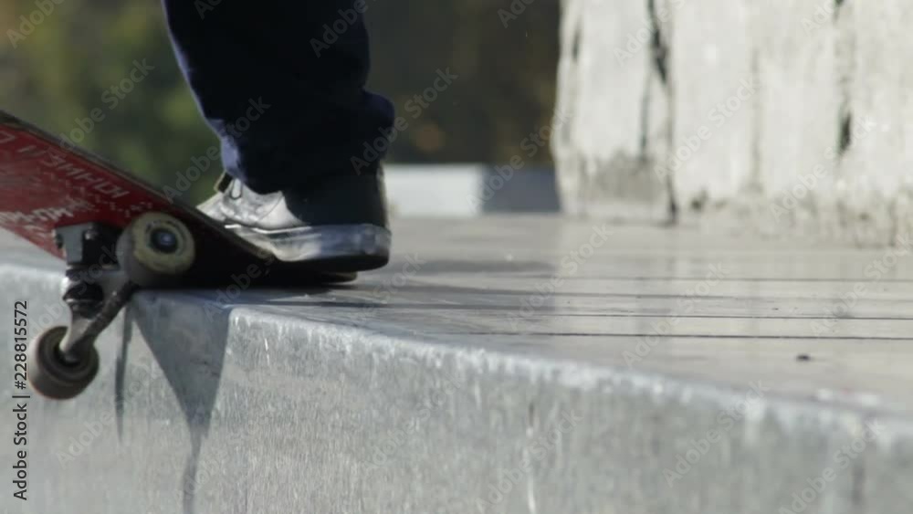 Skateboarder does the grind trick crooked on granit ledge on memorial